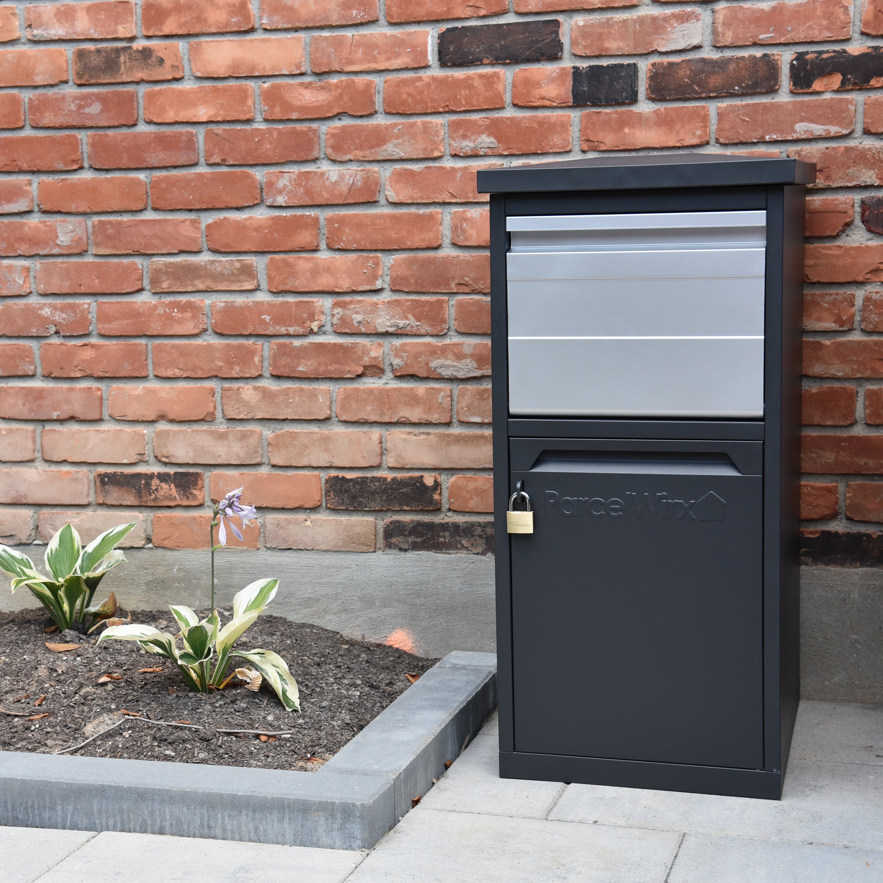 Parcelwirx drop box with chute locked against a brick house