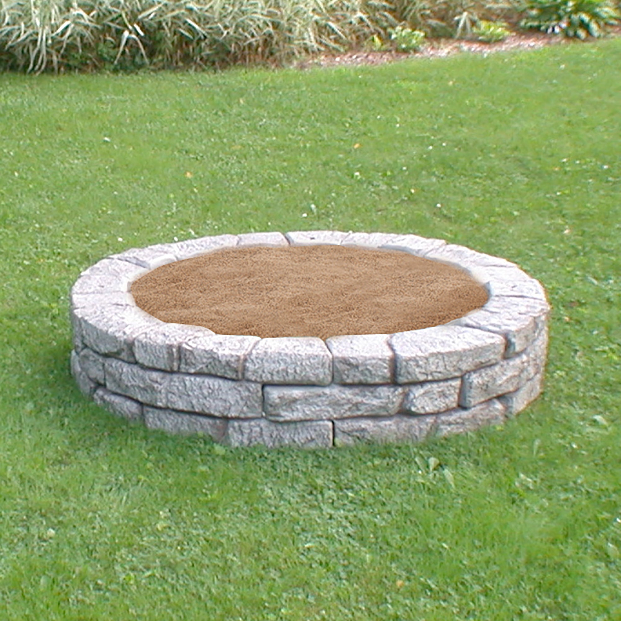 Four pieces of curved rock lock making a circular sandbox with sand inside