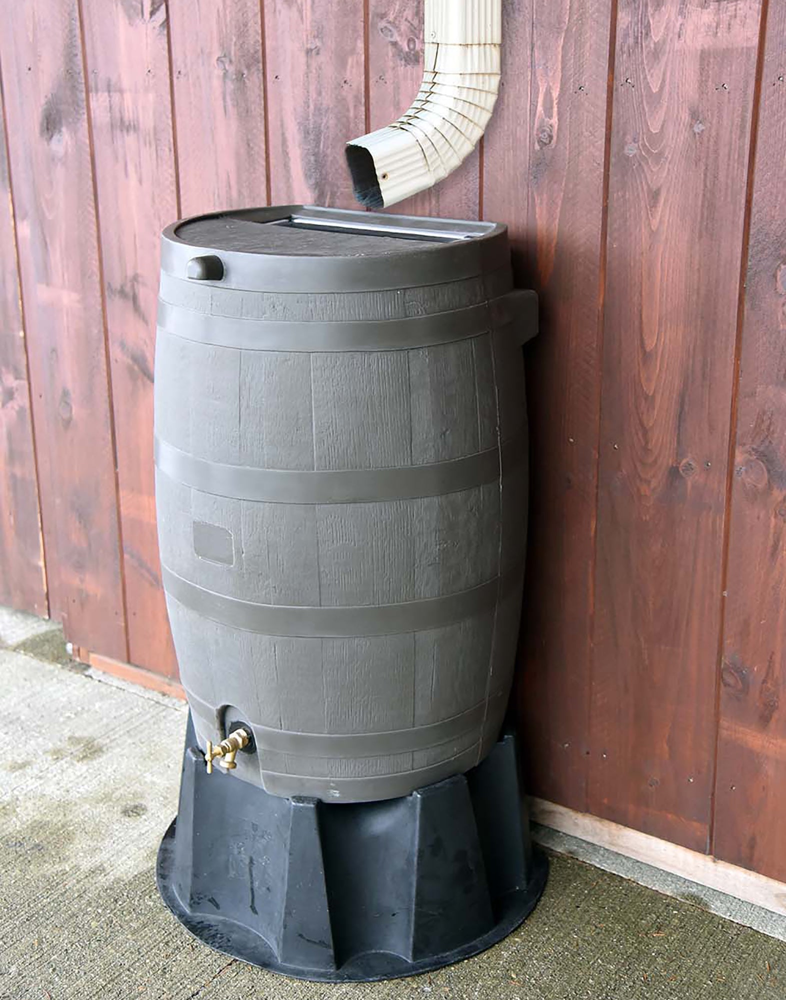 brown flat back rain barrel on black stand with wood background