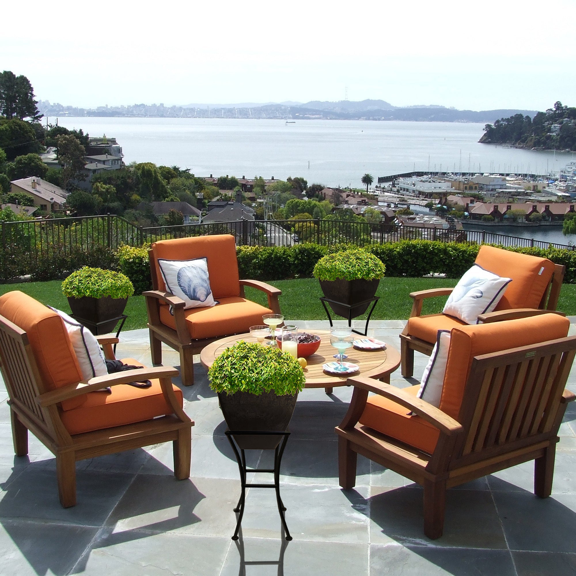 graphite square planter on stand on patio with table and patio chairs overlooking harbour