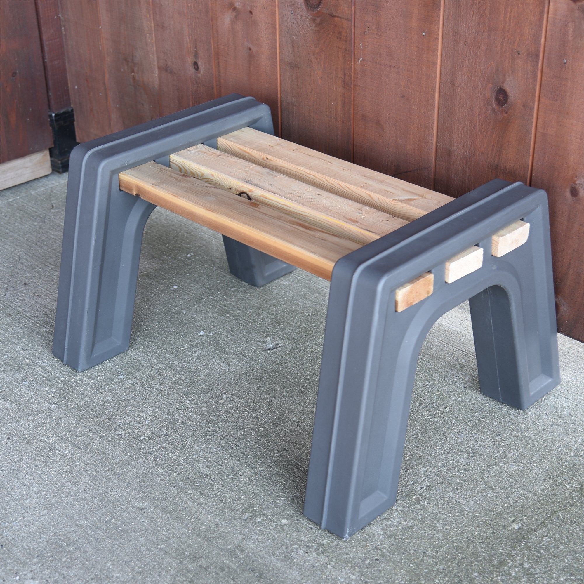 Graphite backless bench with wood against a wood wall